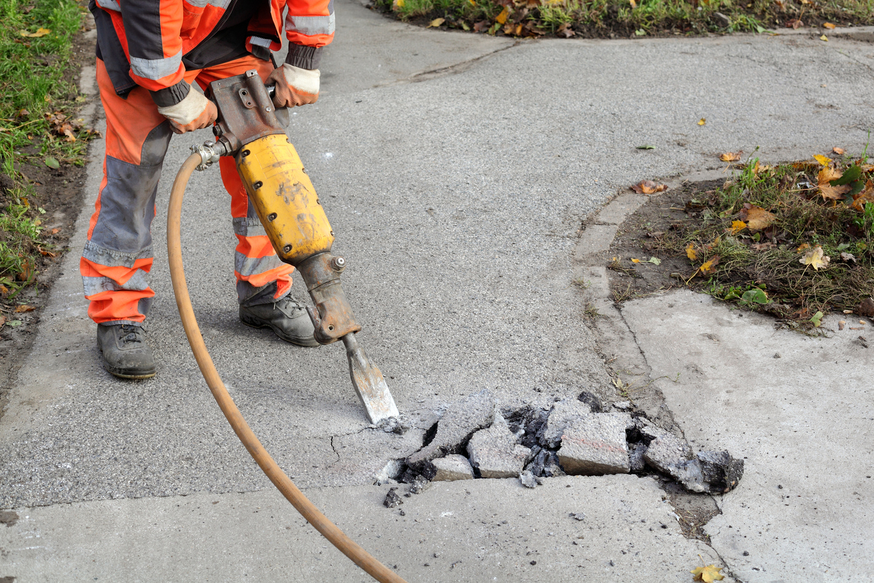 Asphalt demolishing, worker and jackhammer