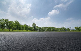 asphalt parking lot surrounded by trees