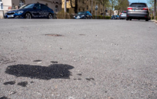 Oil leak from old car on the street