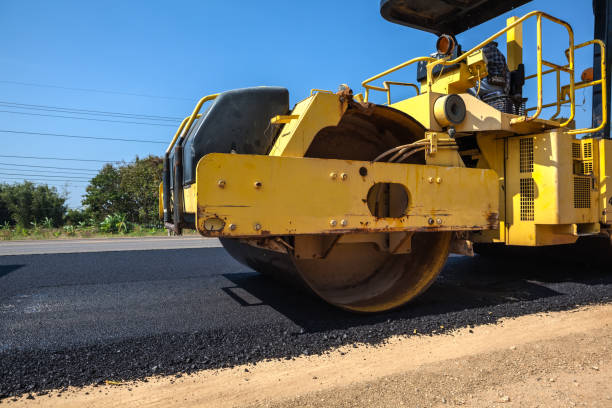yellow asphalt roller truck on a newly paved road