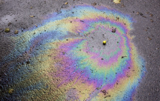 Iridescent spot of oil on the asphalt