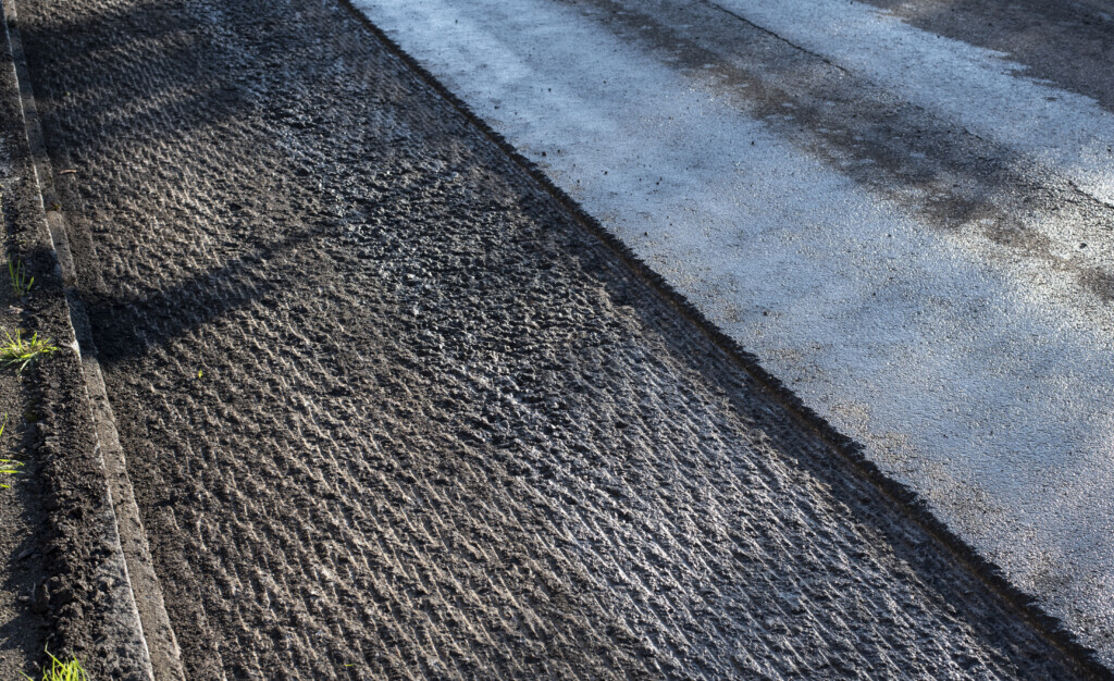 an asphalt street under renovation with milled tarmac