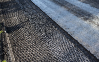 an asphalt street under renovation with milled tarmac