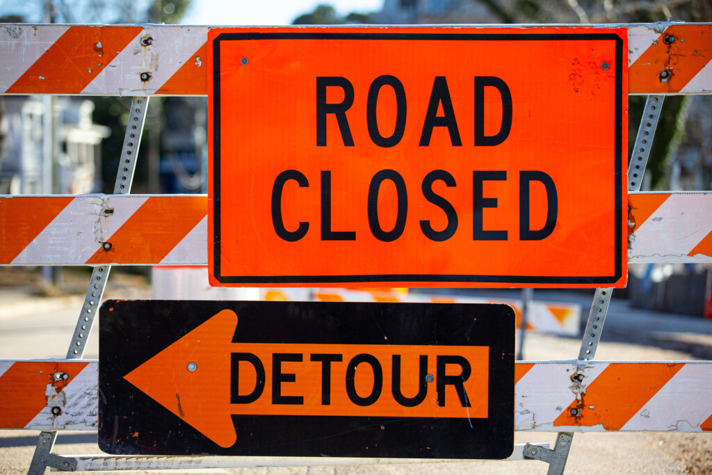 a road building barrier with road closed and detour signs