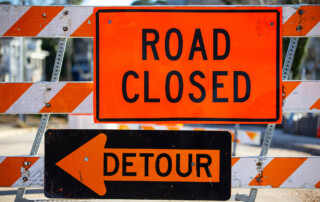 a road building barrier with road closed and detour signs