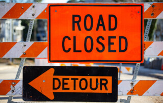 a road building barrier with road closed and detour signs