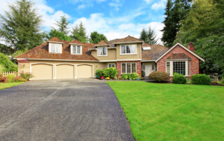 Luxury house exterior with brick trim and an asphalt driveway